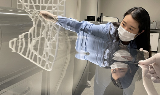 코오롱인더스트리 연구원이 샤오미 폴더블폰 미믹스 폴드에 적용된 투명 폴리이미드 필름(CPI®)을 점검하고 있다. <코오롱인더스트리 제공>